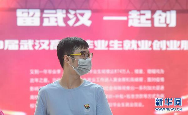 一名求职者在江汉大学校园内举办的招聘会现场寻找合适的岗位（6月1日摄）。这是疫情发生后，武汉举办的首场高校毕业生专场线下招聘会。 新华社记者 程敏 摄