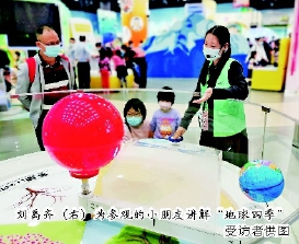 刘禹齐(右)为参观的小朋友讲解“地球四季” 受访者供图 刘禹齐(右)为参观的小朋友讲解“地球四季” 受访者供图