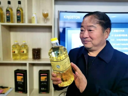 谢焕友向记者介绍食用茶油的好处。人民政协网记者付振强 摄