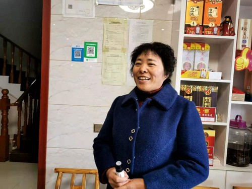 李纪芳向记者介绍民宿经营情况。人民政协网记者付振强 摄