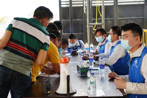 4月6日，在科伦坡港口城接种点，“蓝马甲”志愿者为前来接种的中国公民进行登记。新华社记者 唐璐 摄