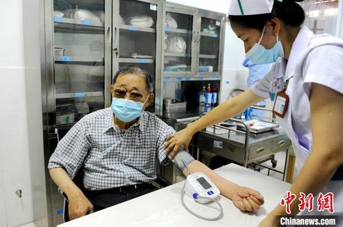 医护人员为大陆知名台商李瑞河(左)做接种前的检查?！≌沤鸫?摄