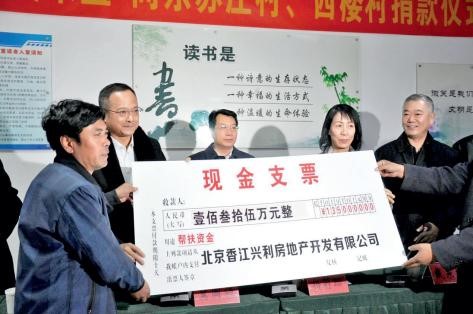 2018 年，吴来盛（左二）与杨莉珊（左四）为天津市武清区河北屯镇的东苏庄村、西 楼村捐款实施自来水管网提升建造工程