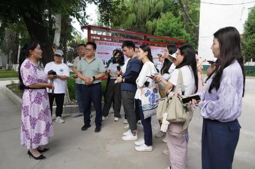 △在新源县喀拉布拉镇，贾娜尔委员（左一）接受记者采访。