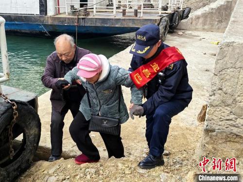 海事志愿者帮助老人乘船。陈道宇 摄