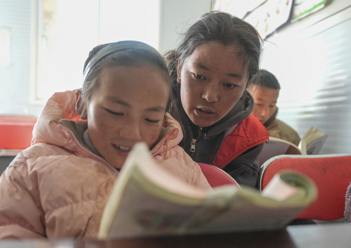 西藏大学学生措姆在西藏定日县曲洛乡热木青村地震安置点为学生辅导作业（2025年1月25日摄）。新华社记者 晋美多吉 摄