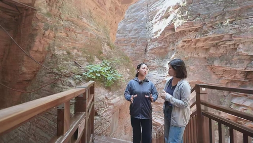 在“瓮圪廊”大峡谷，冯芬芬委员（左）向记者讲述崔振芳烈士的故事。