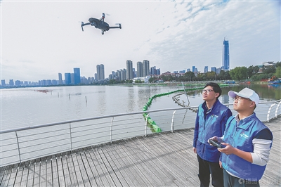 技术人员在湖边操控无人机进行环境监测