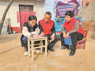 陈坤凤（右一）和志愿者到结对帮扶家庭了解贫困学生的生活学习情况。（图片由受访者提供）
