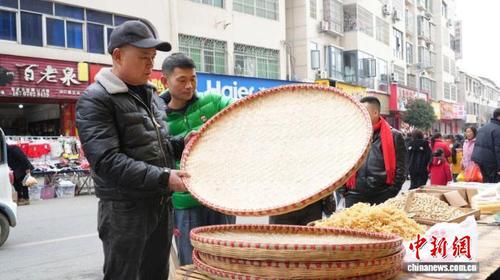 图为江西省九江市修水县山口镇的年集上，农户在选购年货。余星 摄