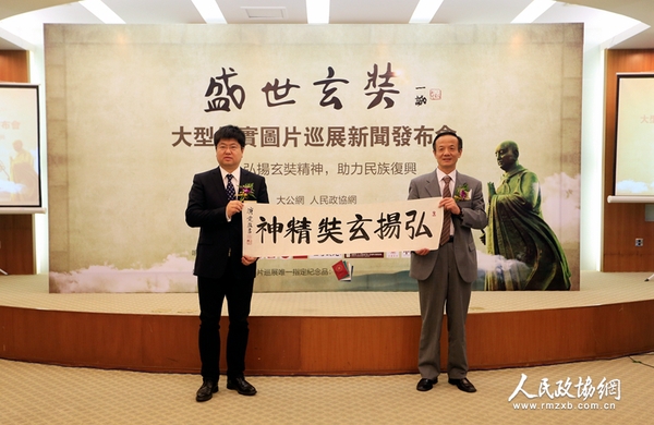 中国佛教协会常务理事陈星桥与大公报社长助理、北京分社社长、大公网执行总裁兼总编辑王文韬展示中国佛教协会驻会副会长演觉法师的墨宝——《弘扬玄奘精神》（摄影：姚勇）