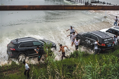 昨日，梁子湖与牛山湖隔堤正式实施爆破作业，完成分洪，人们躲避爆破后激起的余浪。新华社记者 肖艺九 摄