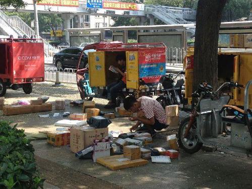 2016年8月2日，北京。多家快递公司的快递员在办公楼下通知、等待收件人下楼取件。中国网 魏婧 摄