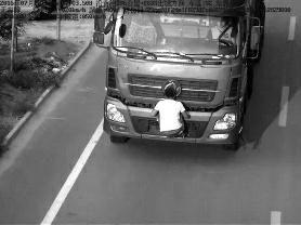 7月28日，男子双手扒在车牌前，这一幕被电子监控设备抓拍